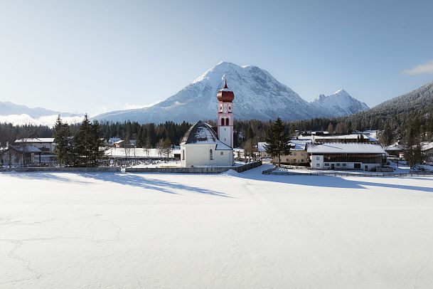 drohnenaufnahme-verschneite-landschaft-pfarrkirche-st