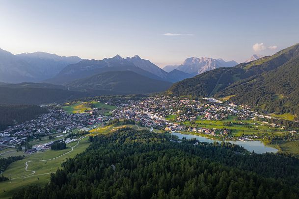 drohnenaufnahme-vom-gschwandtkopf-auf-seefeld-bei-sonnenuntergang-viel-wald-1