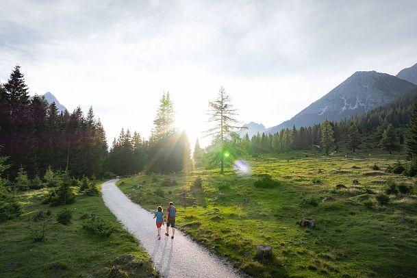 drohnenaufnahme-wanderung-im-gaistal-im-sommer-paar-auf-wanderweg-bei-tiefstehender-sonne-1