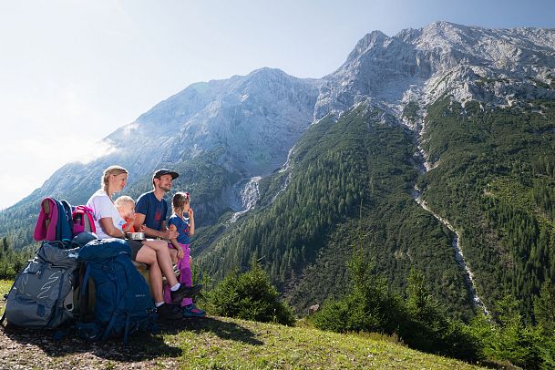 familien-weitwanderung-im-gaistal-familie-macht-pause-auf-bank-blick-auf-hohe-munde-1