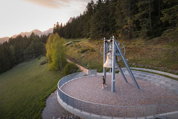 friedensglocke-moesern-zur-sonnenuntergangsstimmung-im-fruehling-drohnenaufnahme-paar-unterhalb-der-glocke-1