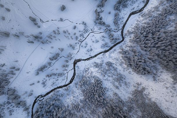 gaistal-natur-im-winter-drohnenaufnahme-flusslauf-aus-der-vogelperspektive-quer-durch-das-bild-1