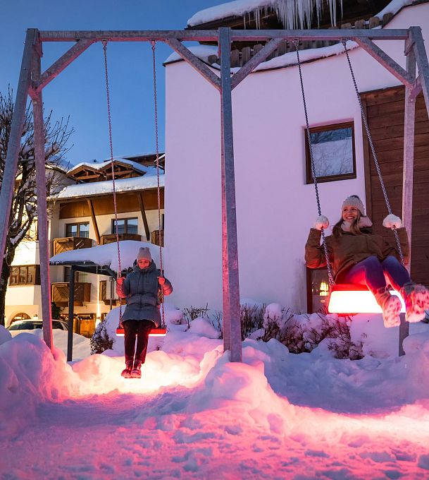 lichterpark-seefeld-zwei-frauen-auf-leuchtschaukel-in-rot-erleuchtet-10