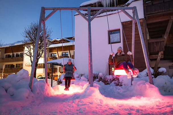 lichterpark-seefeld-zwei-frauen-auf-leuchtschaukel-in-rot-erleuchtet-29