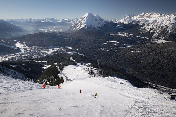 skifahrerin-an-der-rosshuette-zwei-skifahrerinnen-auf-abfahrt-von-der-bergstation-mit-blick-auf-hohe-munde-1