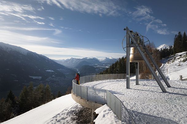 winterwandern-paar-friedensglocke-drohnen-nahaufnahme-paar-steht-am-gelaender-blick-ins-inntal-1