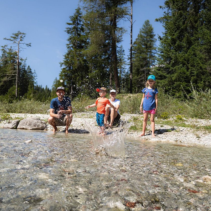 Familien-Weitwanderung im Gaistal - Familie an Leutascher Ache - großer Stein fällt grade ins Wasser