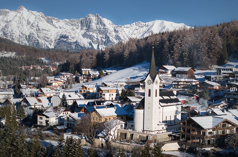 drohnenaufnahme-reith-im-winter-kirche-reingezoomt-mit-wettersteingebirge-im-hintergrund-10