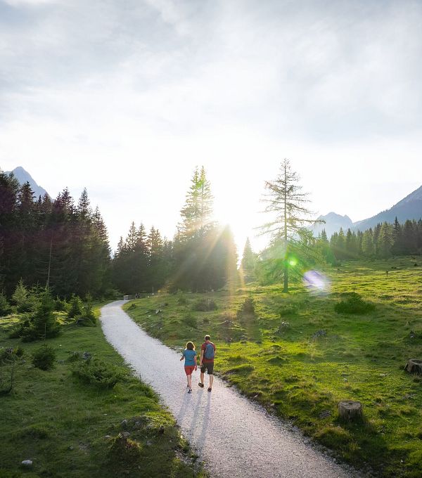 drohnenaufnahme-wanderung-im-gaistal-im-sommer-paar-auf-wanderweg-bei-tiefstehender-sonne-1