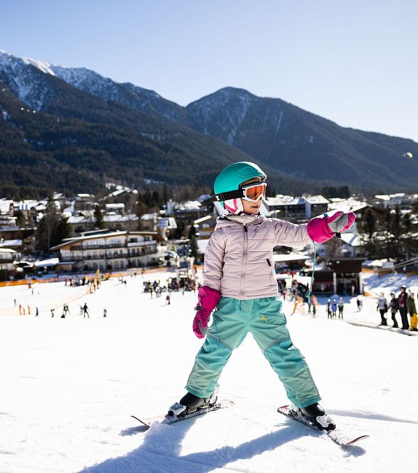 familien-skifahren-in-der-region-seefeld-kind-auf-dem-geigenbuehel-zeigen-mit-hand-1