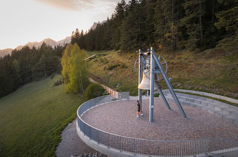 friedensglocke-moesern-zur-sonnenuntergangsstimmung-im-fruehling-drohnenaufnahme-paar-unterhalb-der-glocke-4