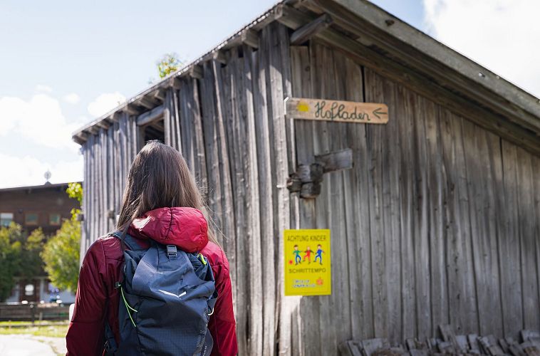 hofladenrunde-leutasch-frau-laeuft-auf-strasse-vor-wirtseppelerhof