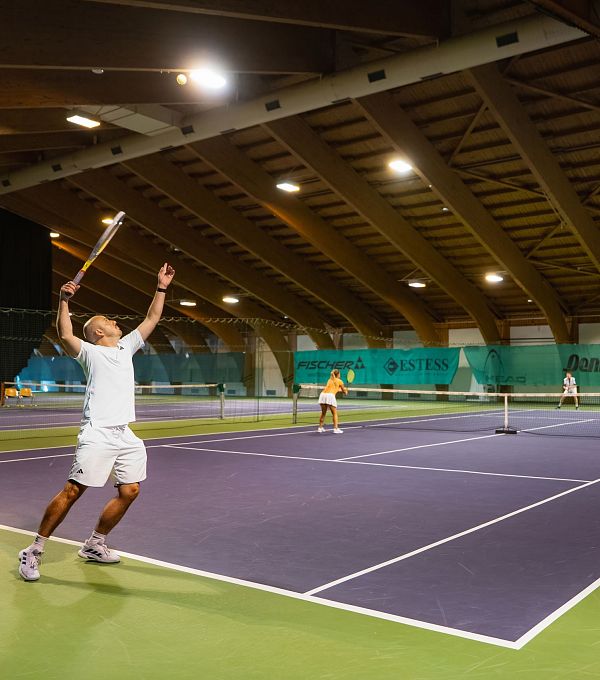 indoor-tennisanlage-seefeld-doppel-mann-schlaegt-auf-ball-in-der-luft-1