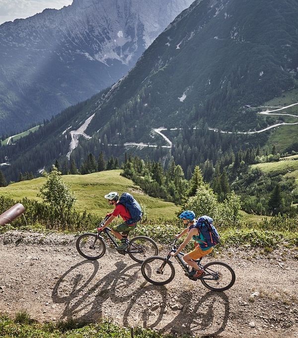 radfahrer-bei-der-auffahrt-richtung-rotmoosalm-im-gaistal-mit-blick-auf-den-forstweg-2-1-3