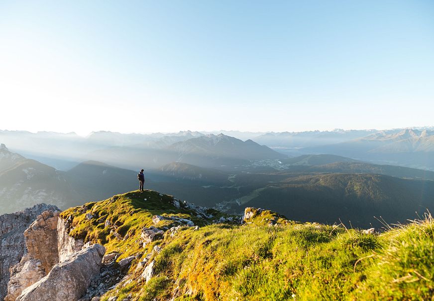 sub1-wanderer-auf-der-gehrenspitze-im-sonnenaufgang-blick-auf-die-region-seefeld-panoramaaufnahme