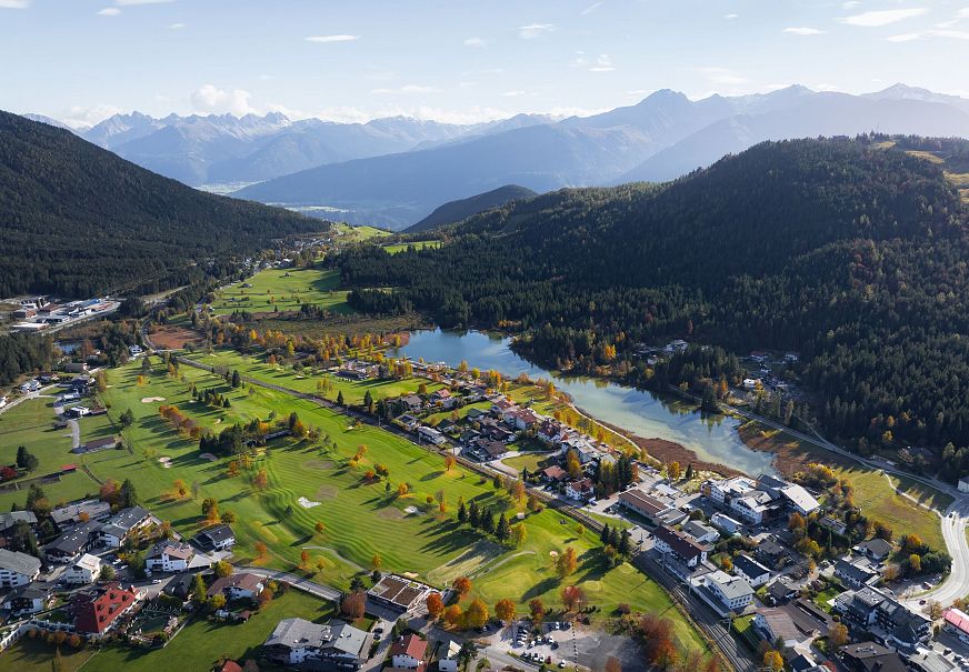 sub1-wildsee-im-herbst-drohnenaufnahme-blick-auf-golfplatz-und-see-mit-bergpanorama-1