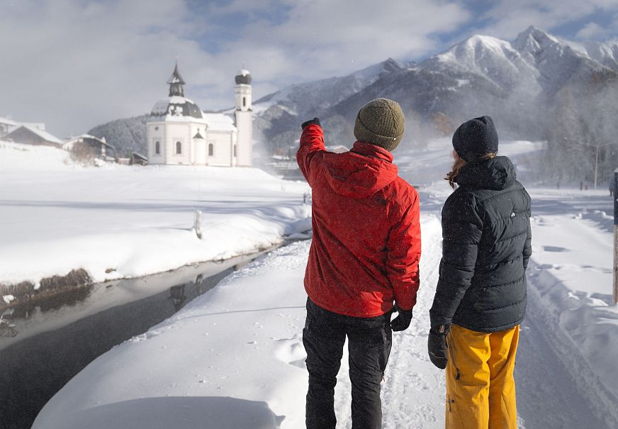 sub1-winterwandern-paar-seefeld-moeserer-tal-mann-zeigt-auf-seekirchel