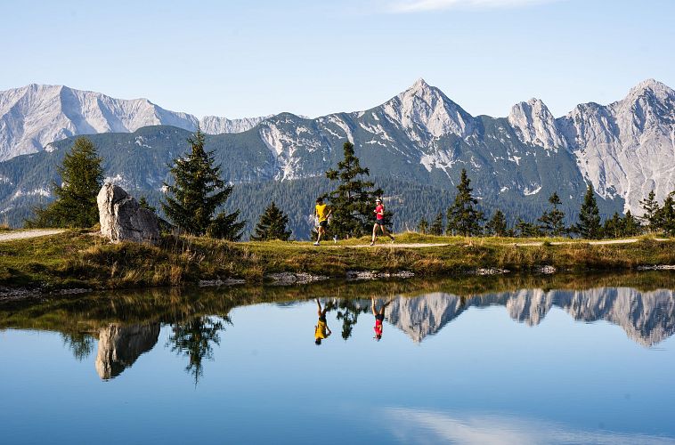 trailrunning-in-der-region-seefeld-laeufer-und-laeuferin-am-kaltwassersee-spiegelung-querformat