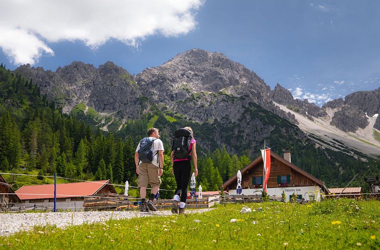 wanderung-zur-eppzirler-alm-im-sommer-mann-und-frau-von-hinten-mit-eppzirler-alm-1