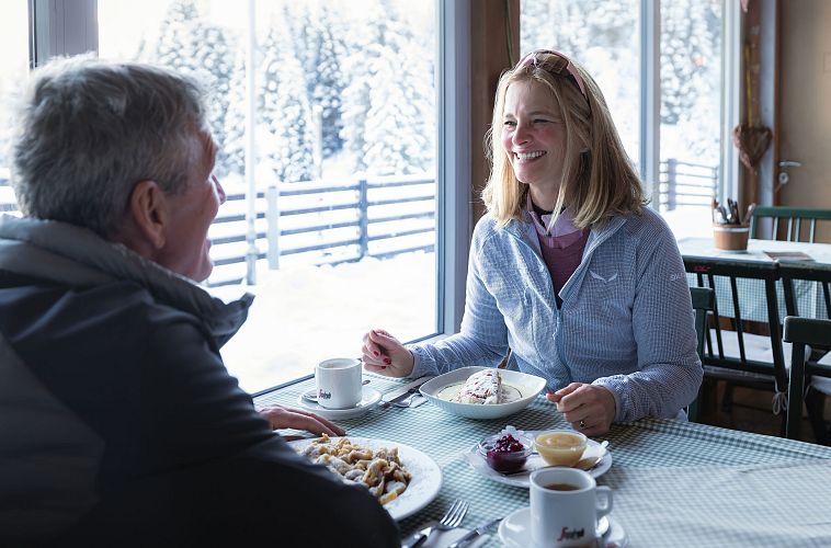 winterwandern-in-der-region-seefeld-mann-und-frau-kehren-in-der-wildmoosalm-ein-frau-lacht-4