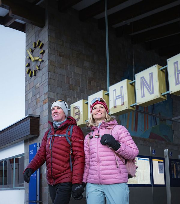 winterwandern-in-der-region-seefeld-mann-und-frau-kommen-in-seefeld-aus-dem-bahnhof-nahaufnahme-1