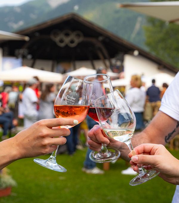 winzerfest-seefeld-2024-anstossen-mit-verschiedenen-weinen-vor-der-festkulisse-1